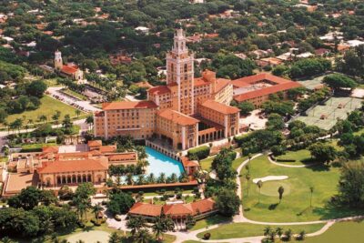 Aerial view of the Biltmore Hotel Coral Gables showing the historic Mediterranean Revival architecture, iconic tower, pool, and golf course.
